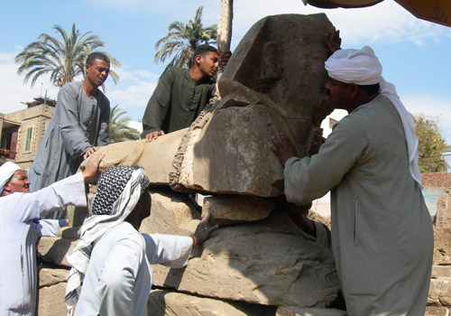 The sphinxes found are often shattered in multiple pieces. Here one is being put on his base again.