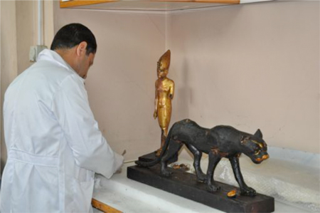 Restorator working on the statue of Tutankhamun standing on a panther. Photo by Stephanie Sakoutis
